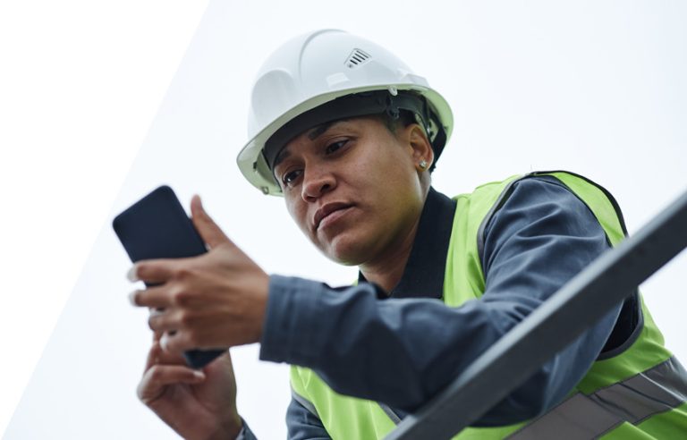 A roofer uses roofing invoice software on a smartphone